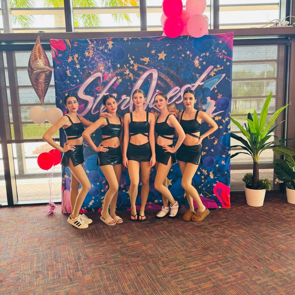 Five Zabava dancers posing in front of a StarQuest backdrop