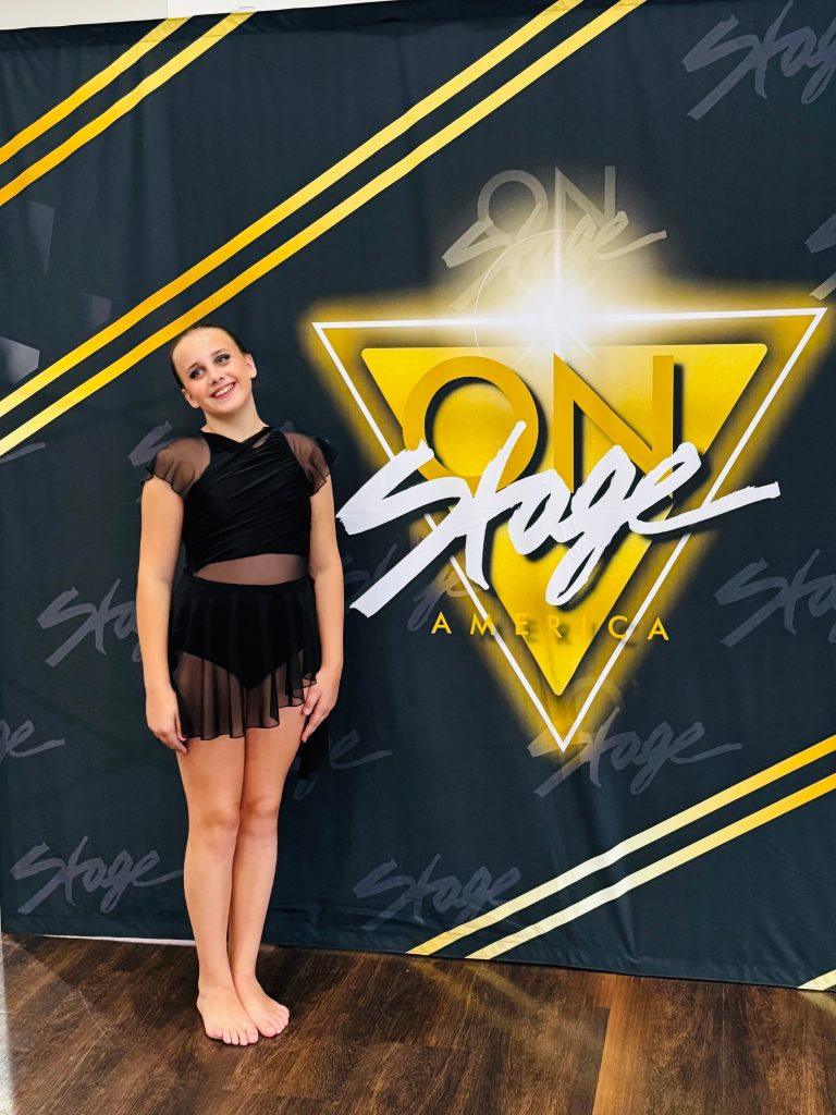 Zabava dancer posing in front of an On Stage America backdrop
